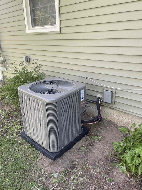 Completed installation of 2.5-ton air conditioning system including ML14KC1-030-230 condenser unit and matching evaporator coil. Unit was properly positioned on composite pad against exterior wall with refrigerant lines connected to electrical disconnect box, ensuring adequate clearance for airflow and service access. All mechanical and electrical connections were completed per manufacturer specifications and local code requirements.