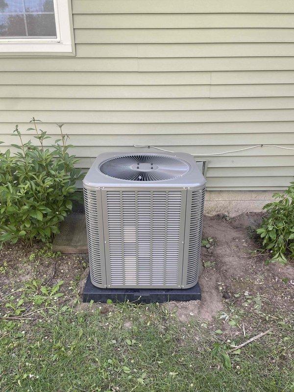 Completed installation of 2.5-ton air conditioning system including ML14KC1-030-230 condenser unit and matching evaporator coil. Unit was properly positioned on composite pad against exterior wall with refrigerant lines connected to electrical disconnect box, ensuring adequate clearance for airflow and service access. All mechanical and electrical connections were completed per manufacturer specifications and local code requirements.
