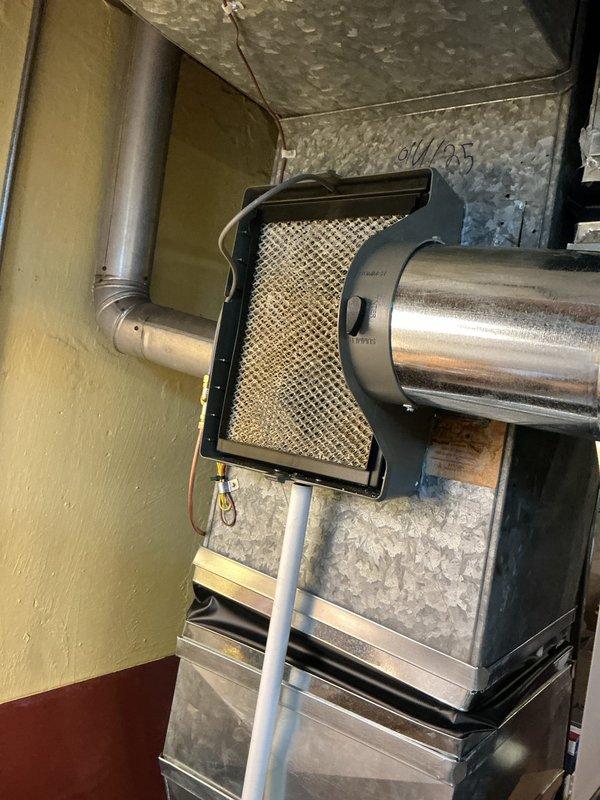 Completed annual cooling maintenance inspection on residential HVAC system. Inspected and photographed air filtration components, including pleated media filters with cardboard frames showing clean condition. Verified proper installation of filter assembly in ductwork system, confirmed adequate airflow through metallic duct components, and documented system configuration in mechanical room with galvanized ductwork and filter housing properly secured.