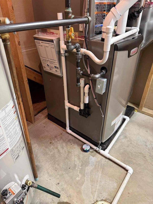 Completed full HVAC system installation in residential basement utility room consisting of new 70,000 BTU Lennox furnace with integrated humidifier and 2-ton air conditioning unit configured for right-side discharge. Installed all necessary PVC venting pipes routed vertically through structure, connected gas supply line with shutoff valve and pressure gauge, and established proper drainage connections. Configured insulated metallic ductwork connections to furnace plenum and verified proper airflow distribution. Reconnected existing electrical service to new equipment and ensured all safety controls operational. All mechanical permits obtained prior to installation and system tested for proper operation upon completion.