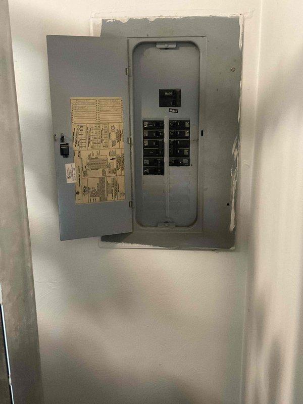 Conducted site assessment for new central air conditioning system installation at residence with no existing central AC infrastructure. Evaluated electrical service capacity at main panel and exterior meter location, documented current electrical configuration to determine compatibility requirements for new HVAC equipment installation, and assessed exterior wall mounting location for condenser unit placement near existing utility connections.