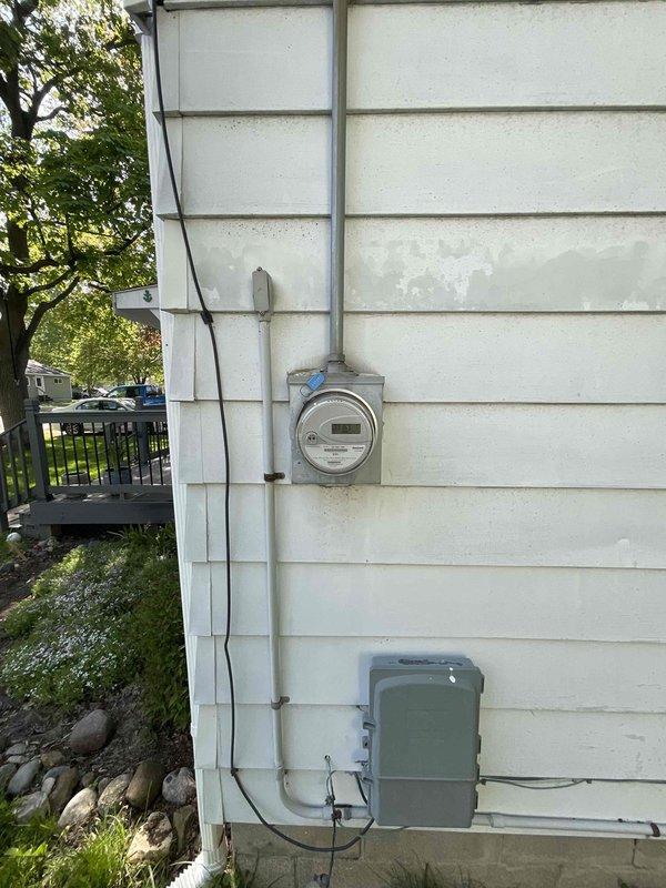 Conducted site assessment for new central air conditioning system installation at residence with no existing central AC infrastructure. Evaluated electrical service capacity at main panel and exterior meter location, documented current electrical configuration to determine compatibility requirements for new HVAC equipment installation, and assessed exterior wall mounting location for condenser unit placement near existing utility connections.