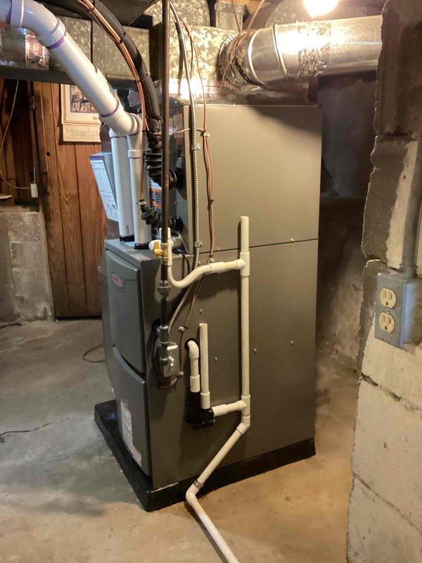 Completed full HVAC system installation in basement area, including 70,000 BTU furnace and 2-ton air conditioning unit with right-side placement. Installed new electrical circuit to support equipment, ran white PVC piping for condensate drainage and venting, and connected flexible metal ductwork with silver insulation to existing distribution system. All mechanical and electrical permits obtained prior to installation, equipment mounted on concrete floor with proper clearances, and system tested for operational functionality upon completion.
