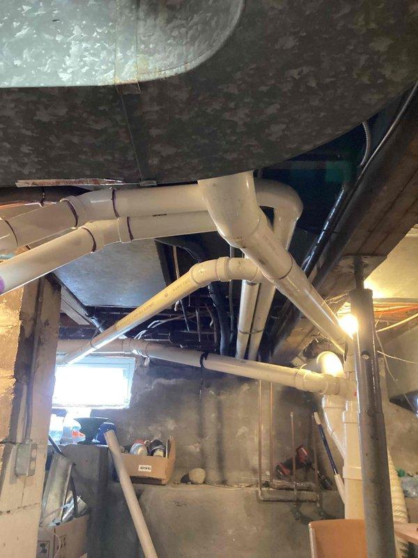 Completed full HVAC system installation in basement area, including 70,000 BTU furnace and 2-ton air conditioning unit with right-side placement. Installed new electrical circuit to support equipment, ran white PVC piping for condensate drainage and venting, and connected flexible metal ductwork with silver insulation to existing distribution system. All mechanical and electrical permits obtained prior to installation, equipment mounted on concrete floor with proper clearances, and system tested for operational functionality upon completion.