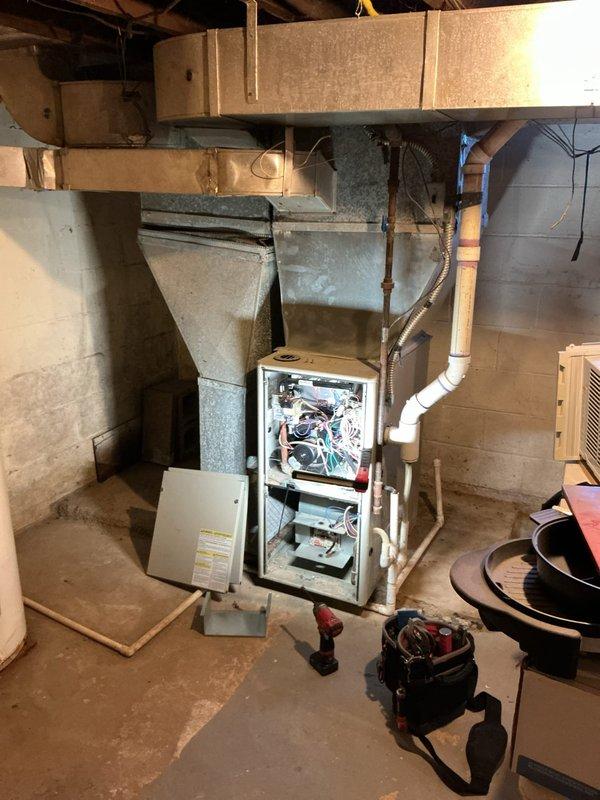 # No Heat Call - Forced Air Furnace

Responded to no heat call on 10-year-old forced air furnace that would not turn on after switch activation. Customer reported burnt smell coming from unit. Upon arrival, confirmed furnace was completely non-operational with no power to system.

## Diagnosis

Opened furnace access panel and performed visual inspection of internal components. Identified significant heat damage and corrosion on main wire harness at motor connection point. Corroded junction showed orange-brown discoloration indicating overheating and electrical failure. Multiple wire terminals at harness connection exhibited deterioration from prolonged heat exposure. Burnt odor traced to damaged wiring harness assembly.

## Work Performed

Disconnected power to unit at service switch for safety. Documented existing condition with photographs showing corroded wire harness and damaged connections. Removed compromised wire harness assembly from blower motor. Cleaned connection points and 