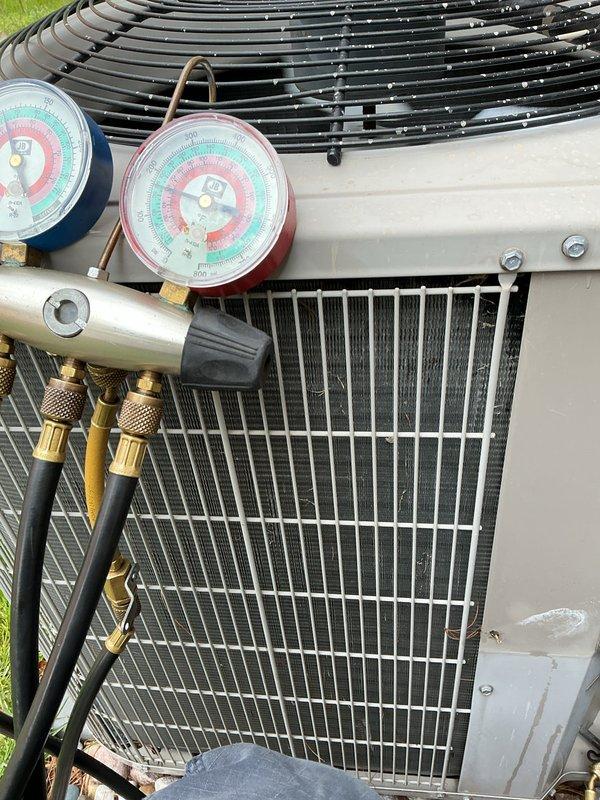Completed annual spring air conditioning maintenance on a 16-year-old Ruud central AC system. Performed comprehensive system inspection including refrigerant pressure testing using manifold gauges, verified proper operating pressures in both high and low sides, inspected outdoor condenser unit coil condition, checked electrical connections, and confirmed system functionality. Indoor air handler and all mechanical components were found to be operational, with system maintaining proper heating and cooling capabilities.