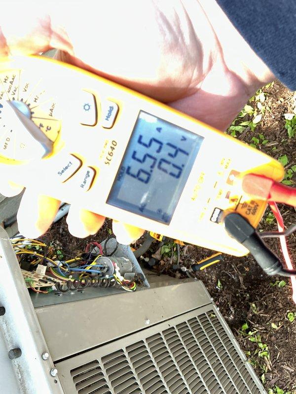 Completed annual cooling maintenance on outdoor HVAC unit. Performed electrical diagnostics using digital multimeter, recording voltage readings of 24V at low voltage controls and 52-65V at capacitor terminals. Inspected internal wiring connections and terminal blocks, confirming all connections secure and properly terminated with no signs of overheating or corrosion.
