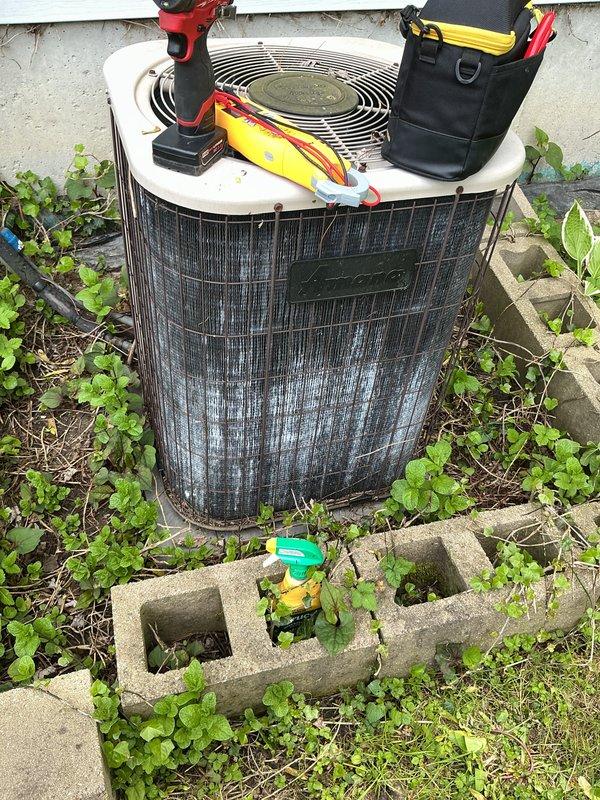 Completed annual Air Care Cooling maintenance on outdoor condensing unit. Performed comprehensive system inspection, checked electrical connections and voltage readings using digital multimeter (measured 5.2V AC), and assessed refrigerant line connections. Unit showed signs of weathering with dirt accumulation on condenser fins and significant vegetation growth around base requiring clearance for proper airflow. All critical measurements documented and system found operational within normal parameters.