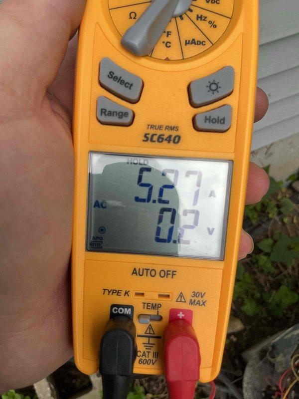 Completed annual Air Care Cooling maintenance on outdoor condensing unit. Performed comprehensive system inspection, checked electrical connections and voltage readings using digital multimeter (measured 5.2V AC), and assessed refrigerant line connections. Unit showed signs of weathering with dirt accumulation on condenser fins and significant vegetation growth around base requiring clearance for proper airflow. All critical measurements documented and system found operational within normal parameters.
