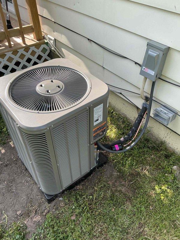 Completed full HVAC system installation including a 70,000 BTU furnace and 2-ton air conditioning unit at rear location. Installed new condenser unit on concrete pad with proper refrigerant line routing, electrical disconnect, and condensate drainage via PVC piping through foundation. Connected all electrical service, secured refrigerant lines to exterior wall with appropriate insulation and service ports, and verified proper system operation. All mechanical components installed per manufacturer specifications with permits obtained prior to installation.