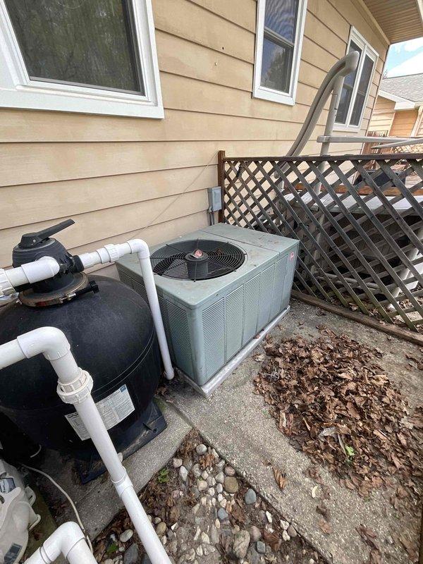 Conducted comprehensive site assessment for complete HVAC system replacement, evaluating existing 9-year-old furnace and 15-year-old air conditioning unit. Inspected indoor furnace installation in basement mechanical room, noting current green furnace with overhead air handler, PVC condensate drainage system, and metallic supply ductwork configuration. Evaluated outdoor condensing unit positioned on concrete pad alongside pool equipment, observing unit condition and clearance requirements. Documented existing system specifications, venting arrangements, gas line connections, electrical wiring, and ductwork transitions to provide accurate replacement equipment recommendations and installation requirements for expedited system changeout.