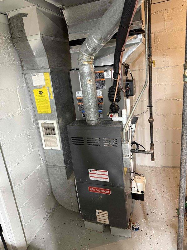 Successfully installed a complete 2-ton air conditioning system with matching evaporator coil on a Goodman furnace unit in the basement mechanical room. The installation included proper refrigerant line connections on the left side of the unit, electrical hookups with conduit and controls mounted to the wall, condensate drainage system with PVC piping and pump, and metallic flex ductwork connected to the furnace plenum. All mechanical and electrical permits were obtained, system was tested and operational, and installation photographs were documented for record purposes.