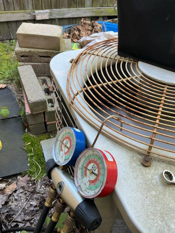 Completed annual cooling maintenance on outdoor heat pump unit. Connected manifold gauge set to measure system pressures and verify refrigerant charge levels. Removed and replaced air filter. Inspected condenser coil and fan guard, noting significant weathering and rust accumulation on exterior components from prolonged outdoor exposure. System operational at time of departure.