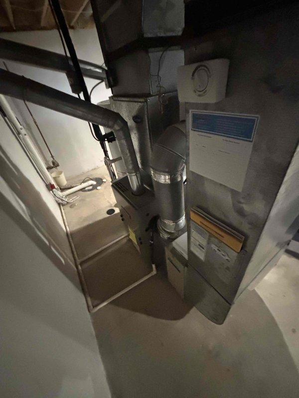 Conducted comprehensive assessment of 30-year-old HVAC system located in basement for equipment replacement estimate. Evaluated existing natural gas furnace, air conditioning unit, air handler, and associated ductwork connections. Documented current system configuration including electrical service panel capacity, equipment placement, and existing infrastructure to develop replacement recommendations for aging climate control system.