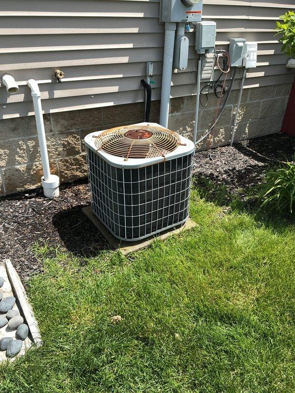 Completed spring AC tune-up on 16-year-old residential air conditioning system. Performed comprehensive maintenance including inspection of outdoor condensing unit, verification of electrical connections at disconnect and meter, assessment of refrigerant lines and PVC condensate drainage, and confirmation of proper fan operation. System operating within normal parameters at time of service; noted moderate rust and corrosion present on condenser top panel consistent with unit age and outdoor exposure.