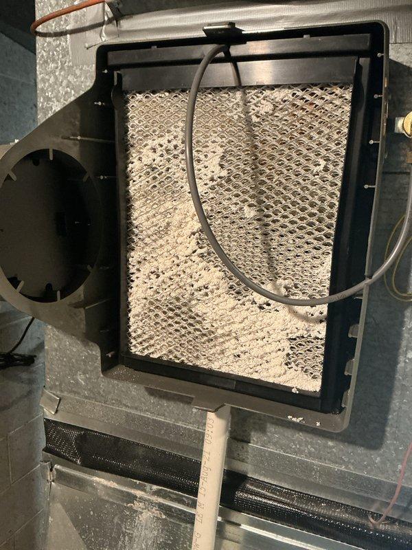 Completed annual cooling maintenance inspection on HVAC system. Identified and replaced heavily soiled air filter showing significant dust and debris accumulation throughout mesh material, along with evaporator coil pad replacement. System access panels secured and unit returned to normal operation with improved airflow efficiency.