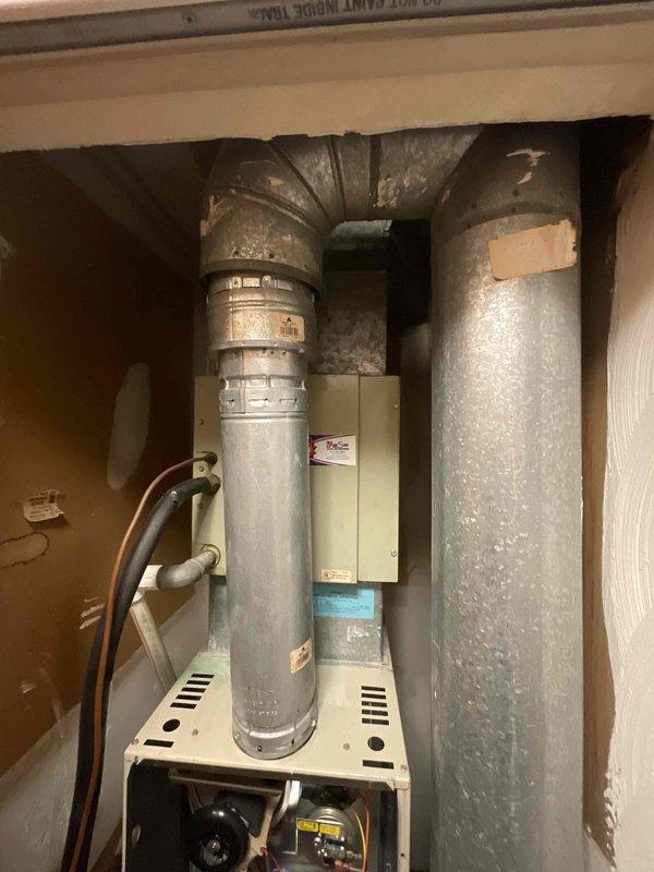 Provided comprehensive estimate for complete HVAC system replacement including furnace and air conditioning unit located in kitchen utility closet. Existing 30-year-old air conditioning system remains operational but has exceeded service life expectancy, while furnace age requires verification. Evaluated confined installation space containing aged ductwork, assessed existing vertical supply and return plenum connections showing significant weathering, and documented current equipment configuration including blower assembly and control components for proper replacement sizing and specifications.