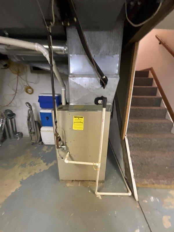 Provided comprehensive estimate for complete HVAC system replacement in basement location, including 25-year-old furnace, water heater tank, and associated electrical upgrades. Assessed existing operational equipment and documented current conditions of beige furnace unit with metallic ductwork and white cylindrical water heater with visible moisture staining at base, noting copper flex connectors and supply piping configuration. Recommended full system replacement to address age-related efficiency concerns and ensure code-compliant electrical service for new equipment installation.