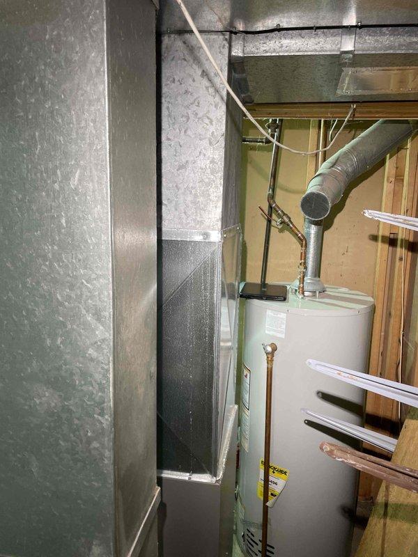 Conducted comprehensive assessment of 20-year-old basement HVAC system to provide replacement estimate for generator, air conditioning unit, and evaporator coil. Inspected existing air handler installation, ductwork configuration, and refrigerant evaporator components. Documented current equipment dimensions and clearances using precision measurements to ensure proper sizing for replacement units. Photographed existing system layout including vertical air handler positioning, metallic ductwork routing, and spatial constraints within unfinished basement utility area. Evaluated operational status of functioning equipment and verified manufacturer specifications on existing evaporator coil rated at 450 PSI. Assessed installation requirements for new generator integration with current HVAC infrastructure and determined necessary modifications for seamless system replacement.