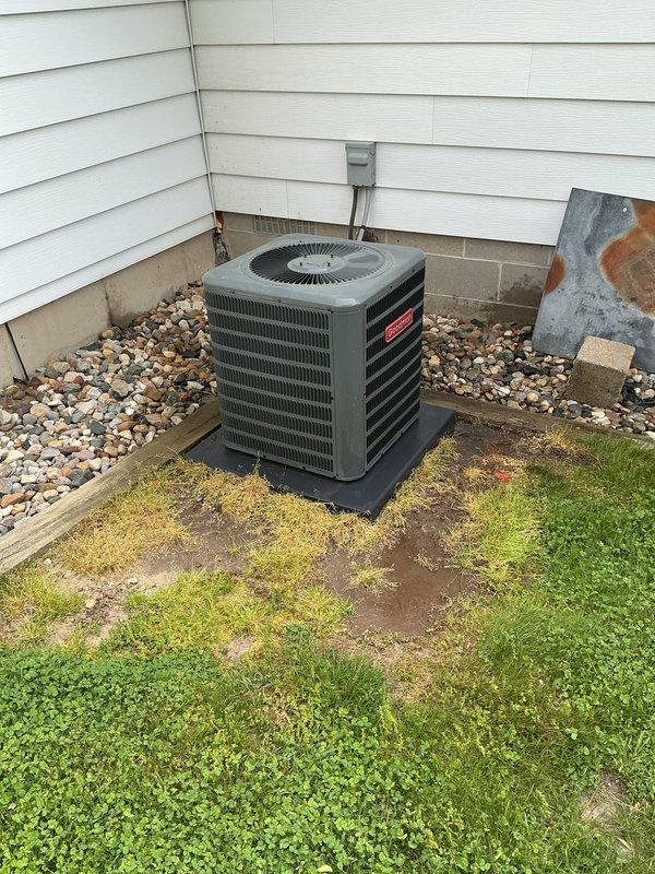 Completed routine annual maintenance on a five-year-old Goodman central air conditioning system. Performed comprehensive AC tune-up including inspection of outdoor condenser unit, verified proper operation of compressor and fan motor, cleaned condenser coils, checked refrigerant levels and pressures, inspected electrical connections and conduit, and confirmed unit is mounted securely on protective pad. System operating within normal parameters with no deficiencies noted. All components functioning properly at time of service.