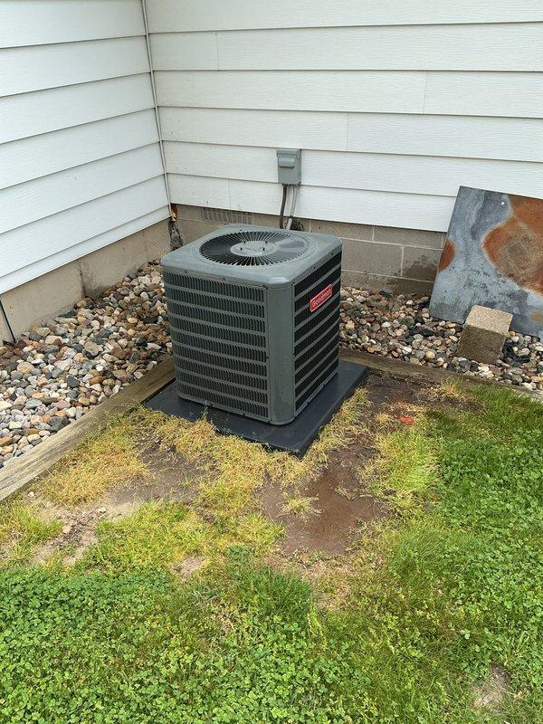 Completed routine annual maintenance on a five-year-old Goodman central air conditioning system. Performed comprehensive AC tune-up including inspection of outdoor condenser unit, verified proper operation of compressor and fan motor, cleaned condenser coils, checked refrigerant levels and pressures, inspected electrical connections and conduit, and confirmed unit is mounted securely on protective pad. System operating within normal parameters with no deficiencies noted. All components functioning properly at time of service.