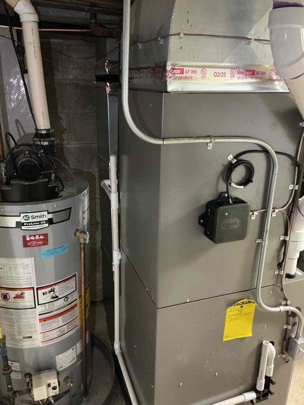 Completed full HVAC system replacement including installation of 110,000 BTU gas furnace and 4-ton air conditioning unit. Furnace installed in basement utility area with proper venting and electrical connections, positioned adjacent to existing water heater. Outdoor Lennox condenser unit mounted on concrete pad in corner location between brick and vinyl siding exterior walls, with refrigerant lines and electrical conduit routed to junction box. All mechanical connections completed per manufacturer specifications and local code requirements, with permits obtained prior to installation.