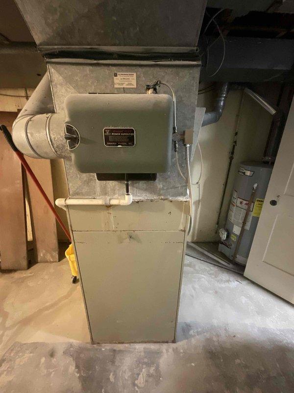 Conducted on-site evaluation for air conditioning system replacement. Existing Bryant AC unit estimated at over 10 years old with customer planning replacement within approximately six weeks. Inspected basement-installed HVAC equipment including furnace with connected ductwork and evaporator coil assembly. Documented current system configuration with photos showing equipment layout, ductwork routing, and utility room access conditions. Provided replacement options and discussed available promotional offers per customer inquiry.