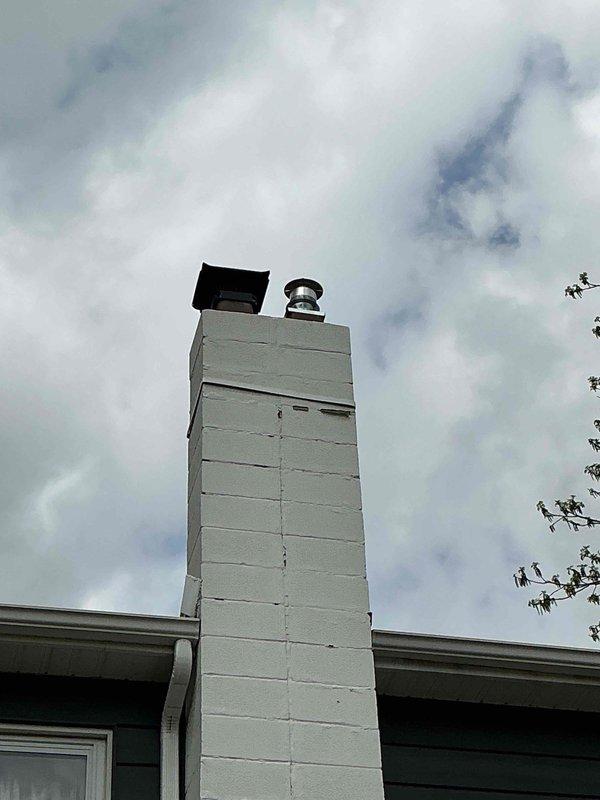 Completed installation of chimney liner system with new metallic flue pipe and rain cap mounted to existing masonry chimney structure. Replaced 70,000 BTU furnace and 2.5 ton air conditioning system with outdoor condenser positioned in right side yard, including humidifier installation and system reconnection. All mechanical permits obtained, ductwork configured and insulated, and system tested for proper operation upon completion.