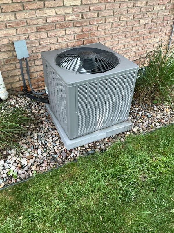 Completed annual air conditioning maintenance on residential condensing unit. Performed comprehensive system inspection including electrical connections, refrigerant lines, and condenser coil examination. Unit found in good operating condition with proper airflow through louvered panels and fan assembly functioning normally.