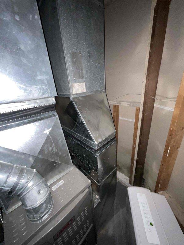 Completed site assessment for air conditioner replacement estimate at residential property. Inspected existing HVAC system including electrical panel, ductwork configuration, and mechanical space layout to determine equipment compatibility and installation requirements. Documented current system conditions through photographs of electrical service panel with circuit breakers, rectangular metal ductwork with flexible connections, and unfinished utility area with exposed framing to provide accurate replacement specifications and identify any necessary modifications for new equipment installation.