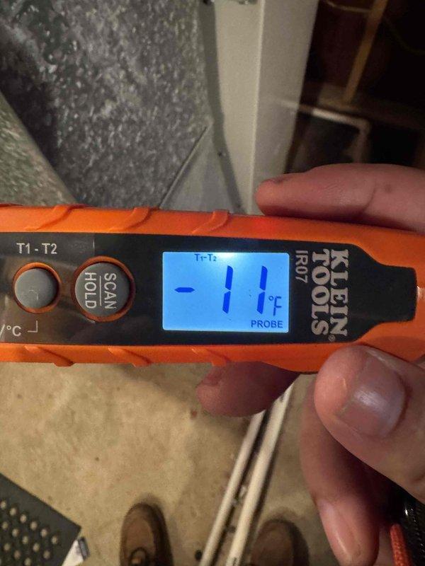 Responded to service call for central air conditioning system not cooling adequately. Upon arrival, performed diagnostic assessment of AC unit and measured supply air temperature at register using infrared thermometer, which confirmed insufficient cooling with probe reading of 11°F temperature differential. Inspected condensing unit, evaporator coil, and associated ductwork in basement utility area. System maintained heating capability but demonstrated reduced cooling capacity. Documented equipment conditions and temperature readings with photographic evidence for service records.