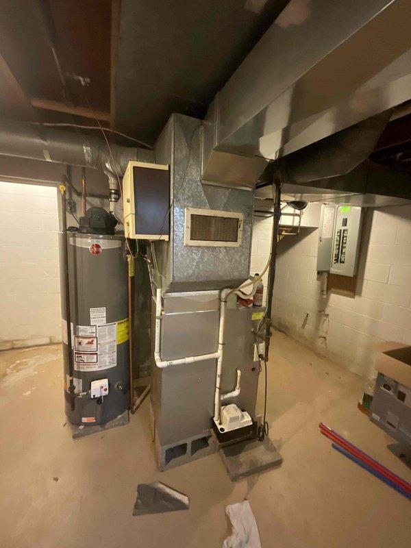 Conducted on-site evaluation for replacement of 30-year-old residential air conditioning system. Inspected existing HVAC equipment in basement mechanical room, including furnace, ductwork configuration, and condensate drainage system. Documented current system layout with photographic evidence showing aged infrastructure, existing duct connections with moisture accumulation, and available installation space. Provided comprehensive replacement quote for new air conditioning unit to address equipment obsolescence and ensure reliable cooling performance.