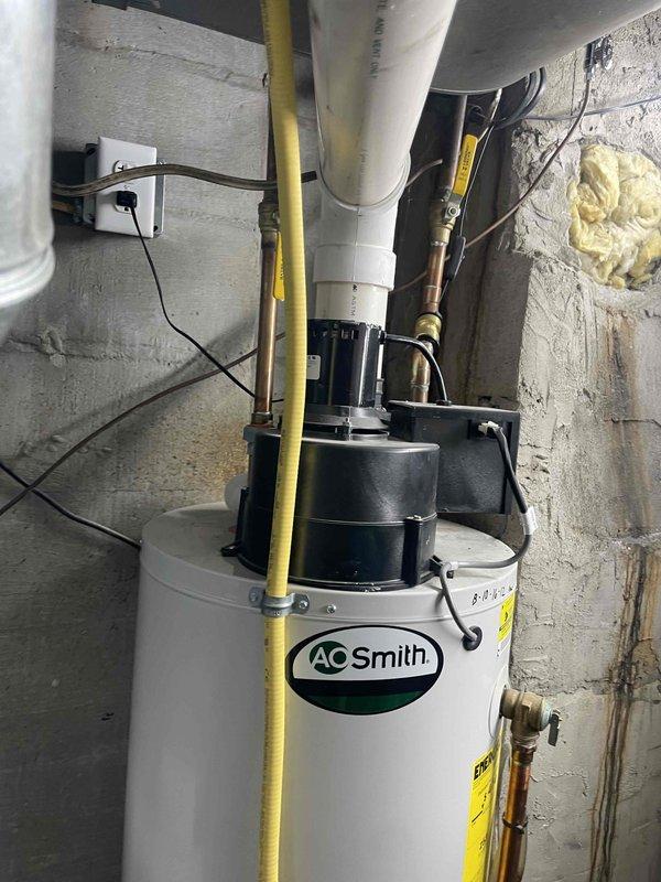 Completed comprehensive HVAC system estimate for residential adult foster care home experiencing multiple equipment failures. Assessed 14-year-old water heater (AO Smith) that had ceased operation, evaluated 14-year-old furnace nearing end of service life, and planned for new air conditioning system installation to replace previously removed unit. Documented existing basement mechanical room configuration including gas line routing, PVC venting, copper water connections, electrical components, and exterior foundation penetrations for proper system replacement planning.