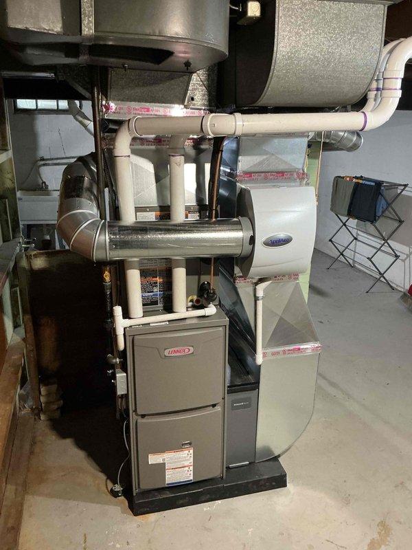 Completed full HVAC system installation including a Lennox 45,000 BTU furnace, 1.5-ton air conditioning unit with rear discharge configuration, and integrated humidifier system in basement utility area. Installed all necessary ductwork, PVC condensate drainage lines, electrical connections, and venting per mechanical permit specifications, with system positioned on protective base pad and all components properly secured and interconnected for optimal airflow and efficiency.