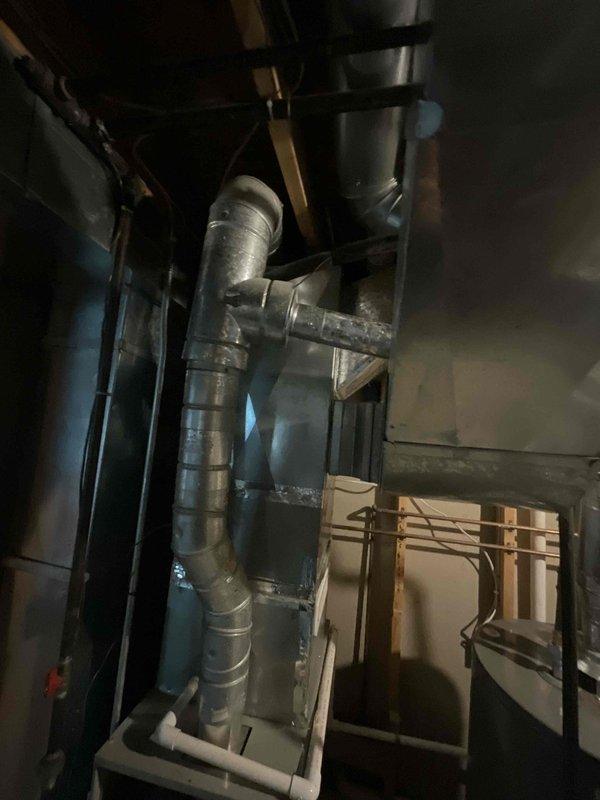 Conducted on-site evaluation for air conditioning system replacement in residential property. Assessed existing AC unit of unknown age located in basement mechanical room alongside furnace, water heater, and laundry equipment. Documented current system configuration, ductwork connections, and available access for equipment removal and installation. Evaluated electrical service, condensate drainage routing, and spatial constraints for new equipment placement. Prepared comprehensive replacement estimate for complete AC system installation to proceed at customer's earliest convenience.