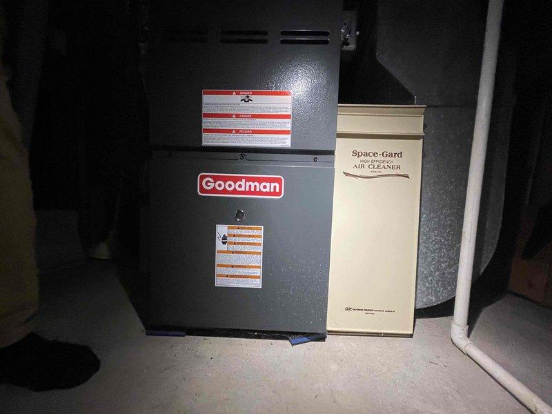 Performed on-site assessment of 16-year-old residential air conditioning system with reported failed outdoor unit. Inspected existing Goodman furnace, Space-Gard high efficiency air cleaner, ductwork configuration, and refrigerant line routing in basement utility area. Documented current system layout including galvanized metal plenum, flexible insulated ductwork, copper refrigerant lines, and floor-mounted air handler to provide comprehensive replacement estimate for complete AC system.