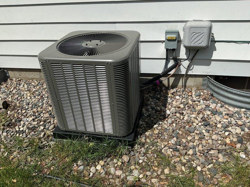 Completed installation of 2.5-ton air conditioning system with evaporator coil on left side of residence. Unit positioned on gravel pad with proper drainage, electrical disconnect and components mounted to exterior wall with conduit connections. All permits obtained, system reconnected and operational upon completion.
