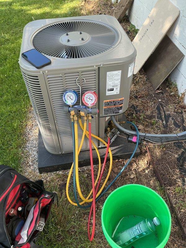 Completed scheduled air conditioning maintenance on residential condenser unit. Performed system diagnostics using manifold gauge set to check refrigerant pressures and verify proper operation. Unit was positioned on protective rubber pad as requested, with all components functioning within normal parameters at time of service.