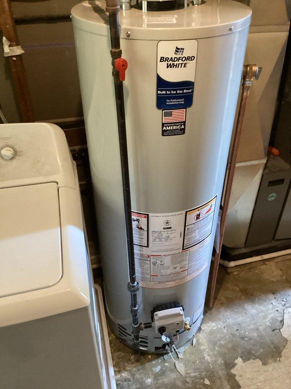 Completed full water heater replacement by draining and removing the existing unit, disposing of old equipment, and installing a new Bradford White RG240T6N tanked water heater. Installation included two dielectric unions to prevent galvanic corrosion between dissimilar metals, a new temperature and pressure relief valve for safety compliance, and six feet of single wall flue pipe with two 90-degree elbows for proper venting. Reconnected water supply lines using two 3/4-inch slip couplings and verified all connections for proper operation and leak-free performance.