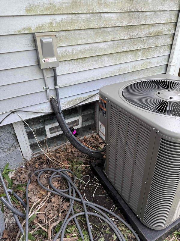 Completed installation of 2.5-ton air conditioning condenser unit with matching evaporator coil system at residential property. Unit positioned on mounting pad at rear of structure with new electrical circuit and disconnect box installed per code requirements. Interior evaporator coil integrated with existing furnace system in basement, with all refrigerant lines, electrical connections, and condensate drainage properly installed and tested. Mechanical and electrical permits obtained and all work performed to local building code standards.