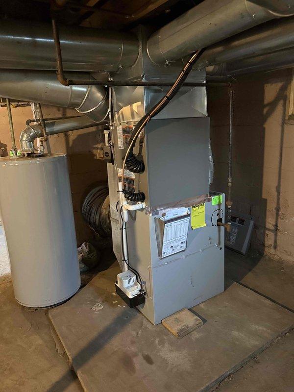 Completed installation of 2.5-ton air conditioning condenser unit with matching evaporator coil system at residential property. Unit positioned on mounting pad at rear of structure with new electrical circuit and disconnect box installed per code requirements. Interior evaporator coil integrated with existing furnace system in basement, with all refrigerant lines, electrical connections, and condensate drainage properly installed and tested. Mechanical and electrical permits obtained and all work performed to local building code standards.