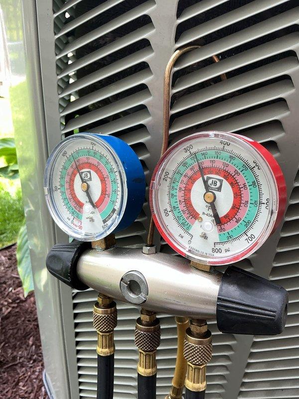 Completed annual cooling maintenance on residential air conditioning system. Performed refrigerant pressure diagnostics using manifold gauge set on outdoor condenser unit, verifying system pressures and refrigerant charge levels within manufacturer specifications. All measurements indicated proper system operation with no issues identified.