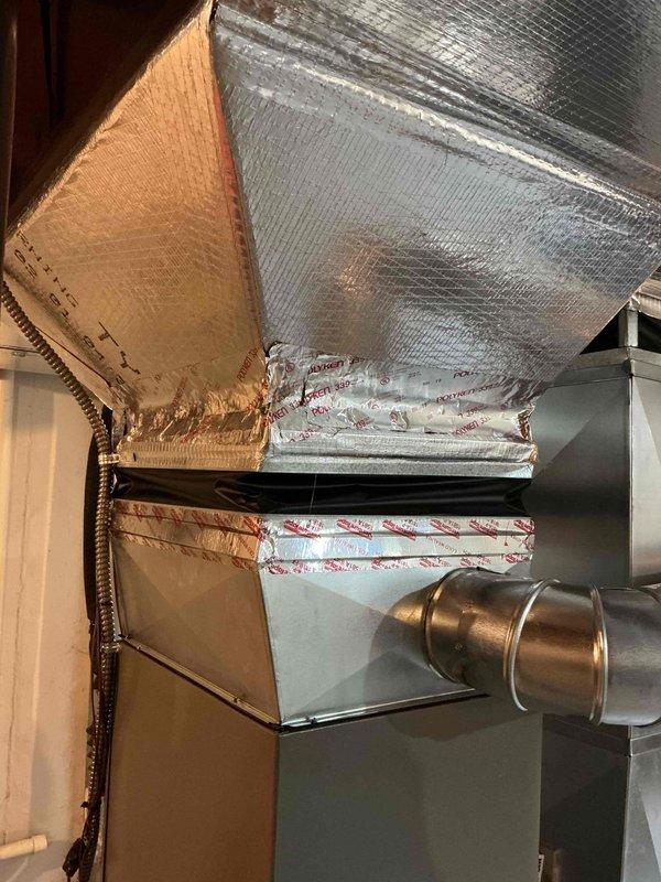 Responded to service call for furnace with peeling duct tape at plenum connection. Inspected HVAC system in basement and found deteriorating foil tape seal where supply plenum meets furnace cabinet. Removed old failing tape, cleaned surfaces, and resealed duct connection with proper HVAC foil tape to restore air-tight seal and prevent conditioned air loss. Verified all PVC condensate drain lines and venting connections secure. System operating normally with proper airflow restored at plenum junction.