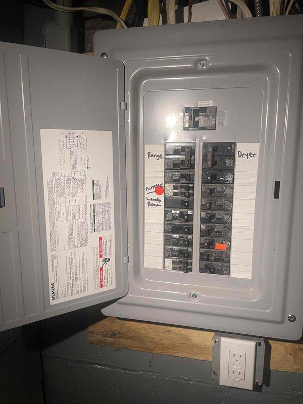 Conducted site evaluation for whole-house central air conditioning installation at single-family residence with existing forced air heating system but no current AC. Assessed electrical panel capacity and available breaker space to accommodate new AC unit requirements, photographed circuit breaker configuration showing adequate service for system addition. Evaluated existing furnace and ductwork infrastructure in basement utility area, confirming compatibility with proposed air conditioning integration and verifying duct system can support cooling distribution throughout home.