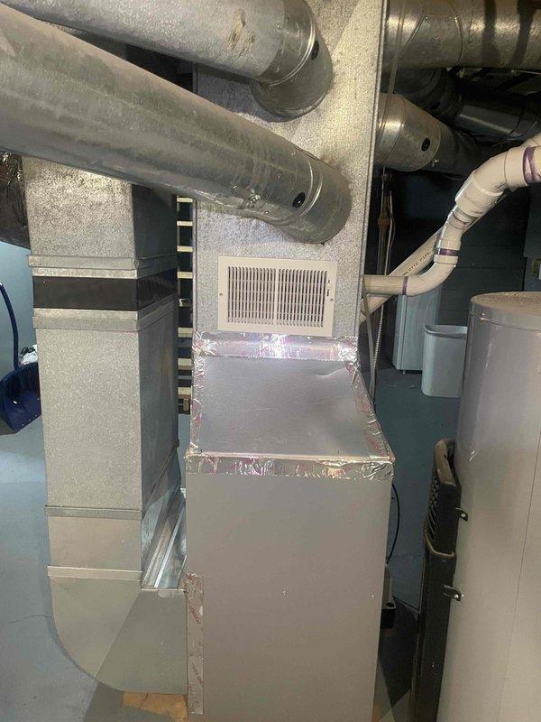 Conducted site evaluation for whole-house central air conditioning installation at single-family residence with existing forced air heating system but no current AC. Assessed electrical panel capacity and available breaker space to accommodate new AC unit requirements, photographed circuit breaker configuration showing adequate service for system addition. Evaluated existing furnace and ductwork infrastructure in basement utility area, confirming compatibility with proposed air conditioning integration and verifying duct system can support cooling distribution throughout home.