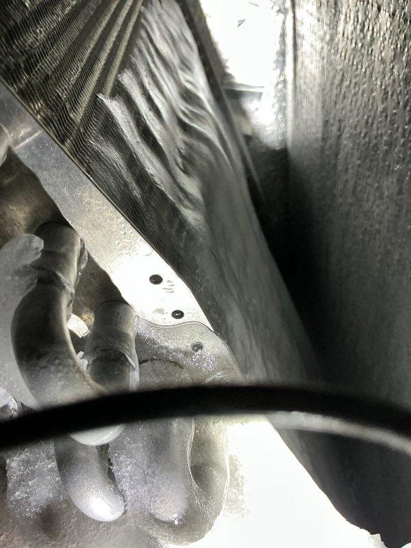 Responded to no cooling complaint on central air conditioning system less than 5 years old. Upon arrival, found evaporator coil completely frozen with heavy ice buildup, confirming customer report of unit running continuously without adequate cooling. Documented extensive frost accumulation on coil assembly and surrounding components. Identified restricted airflow as primary cause of coil icing, likely due to dirty air filter or reduced system airflow. Recommended system shutdown to allow complete ice melt, filter replacement, and thorough airflow assessment before restart to prevent recurrence and potential compressor damage.