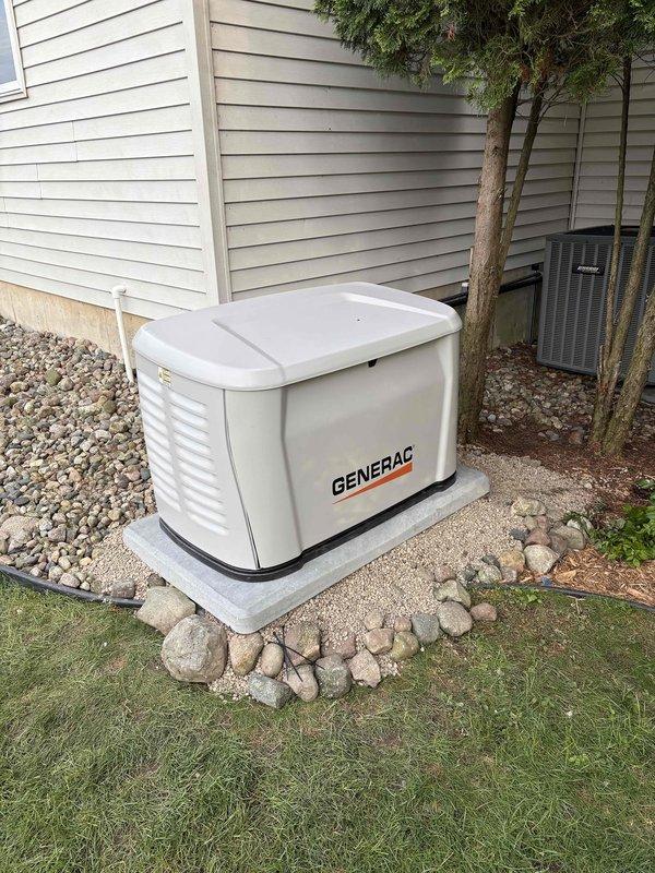 Completed installation of Generac 14kW standby generator with 200-amp automatic transfer switch on concrete pad with proper clearances from residential structure. Generator positioned alongside existing HVAC equipment with appropriate ventilation access, mounted on prepared concrete foundation surrounded by decorative landscaping stone. Electrical connections completed per manufacturer specifications and local code requirements. Permits obtained prior to installation, with electrical inspection coordinated and scheduled. All conduit runs installed from generator to transfer switch location, Service Finance paperwork processed and executed with identification documentation on file. Unit tested and operational upon completion.