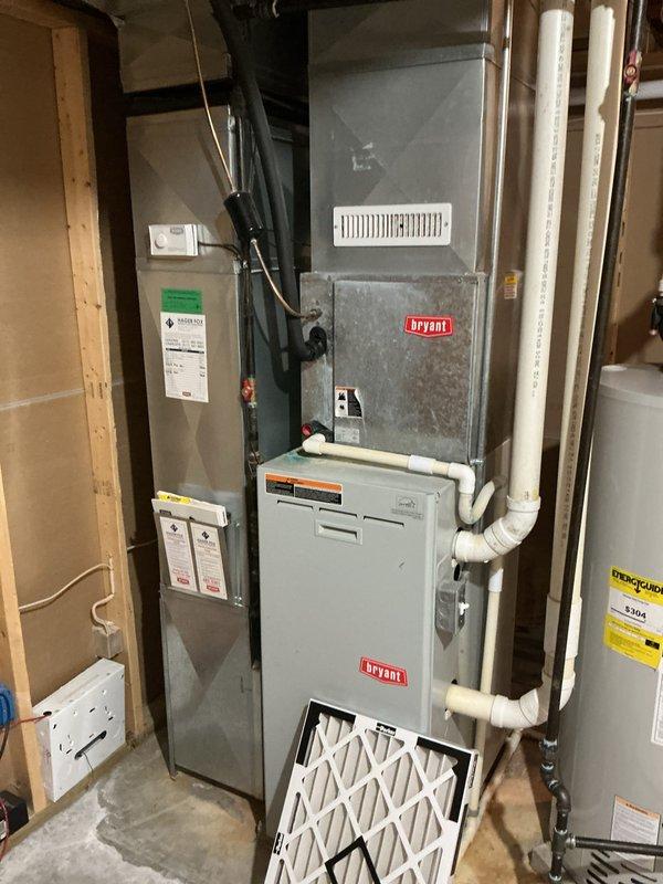 Completed routine Air Care Maintenance on Bryant HVAC system, including inspection of furnace and evaporator coil assembly. Noted significant oxidation and corrosion on copper evaporator coil with rust staining on cabinet housing, indicating age and moisture exposure. Replaced air filter at base unit and documented system condition with photographs for maintenance records.