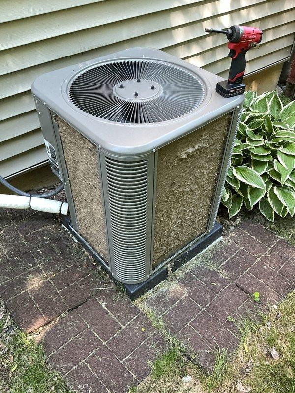 Completed comprehensive ComfortGuard Maintenance Package on outdoor condensing unit. Performed full system inspection, cleaned condenser coils and fan assembly, checked refrigerant lines and electrical connections, verified proper operation of all components, and documented unit condition with photographic evidence showing weathered exterior housing with normal environmental wear patterns.
