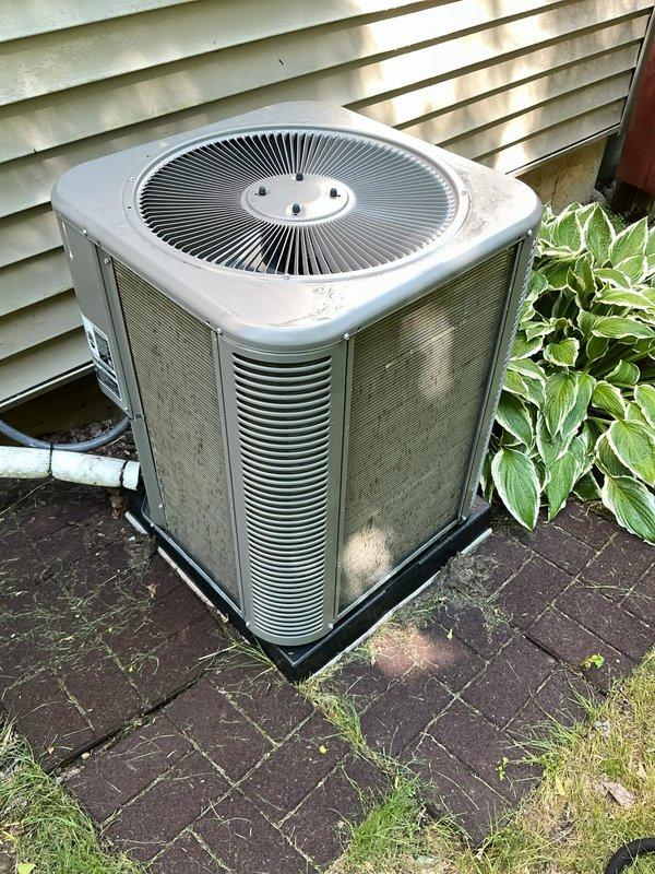 Completed comprehensive ComfortGuard Maintenance Package on outdoor condensing unit. Performed full system inspection, cleaned condenser coils and fan assembly, checked refrigerant lines and electrical connections, verified proper operation of all components, and documented unit condition with photographic evidence showing weathered exterior housing with normal environmental wear patterns.